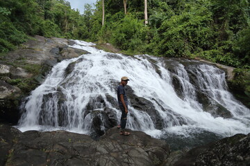 Man standing on the rocks at Khao Soi Dao waterfall in Chanthaburi, Thailand