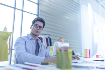 Young men wear glasses as clothing designers. Looking at the camera