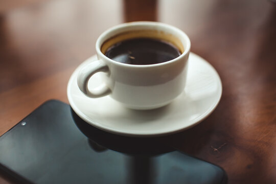 Mock up of a cup of cold coffee on wood table and had blur nature.. Mock up of a cup of cold coffee on wood table and had blur nature..