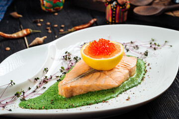 Salmon fillet spinach sauce lemon and red roe