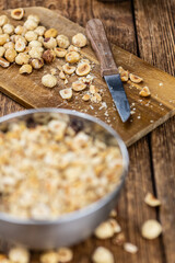 Portion of freshly chopped Hazelnuts (close up; selective focus)