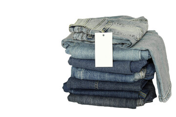 A stack of new jeans with white paper tag mockup and copy space isolated on white