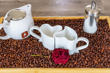 An arrangement of heart cups on a tray with coffee beans
