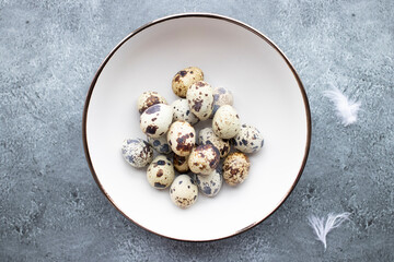 Quail eggs inside a decorative plate and on a background