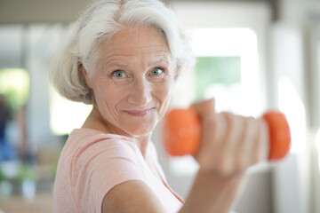 Portrait of senior woman lifting dumbbells, fitness exercices - obrazy, fototapety, plakaty