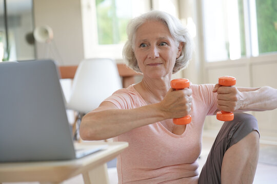 Senior Woman Doing Fitness Exercises With Virtual Class