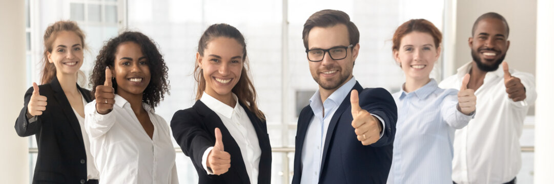 Group of multi ethnic staff standing in row smiling showing thumbs up hand gesture, concept of career success growth, best corporate service feedback. Horizontal photo banner for website header design