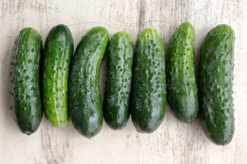 Fresh cucumbers from garden beds on a wooden surface