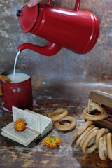 Rustic style breakfast - fresh farm milk, crispy bagel, old book and garden flowers