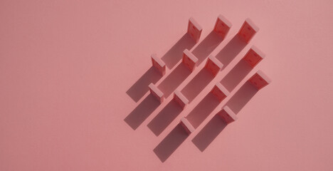 The domino chips pink on a pink background view from above make shadows on the background. Abstract photo with text space        