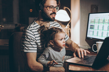 Father and daughter are working on a laptop. businessman working from home and watching the child....