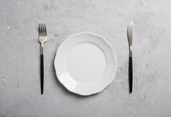 minimal table setting with fork and knife on gray background