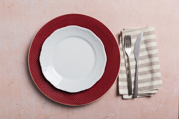 Table setting with silverware on pink concrete