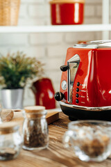 Close up photo of a red toaster on a kitchen table - obrazy, fototapety, plakaty
