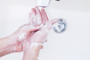  washing hands rubbing with soap and water.