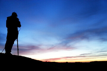 Photographer silhouette in the night sky horizon