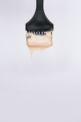 stylist kneads hair dye in a black container close up