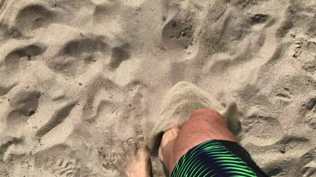 Italy, Pavia may 2020 - End of quarantine home lockdown due covid19 Coronavirus - feet of a man walk in the sand of the beach and arrive to the clear water of the sea - freedom after pandemic