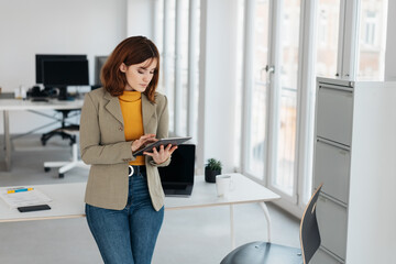 Young businesswoman engrossed in her tablet