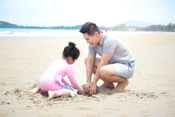 Happy family, father and little daughter having fun and spending time togetheron summer vacation, dad playing with kid on tropical beach