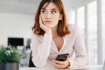 Fototapeta premium Young businesswoman looking thoughtfully aside