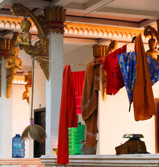 Open hallway decorated with golden buddha images and used to hang and dry typical monks clothes in...