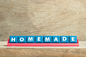 Tile letter on red rack in word homemade on wood background
