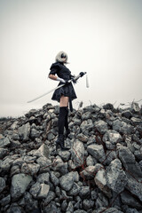 cosplay woman with sword in suit standing on rock