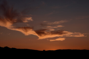 Obraz premium Beautiful peach clouds over the sea and mountain