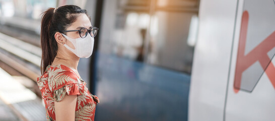 young Asian woman wearing Surgical face mask protect coronavirus inflection at public train...