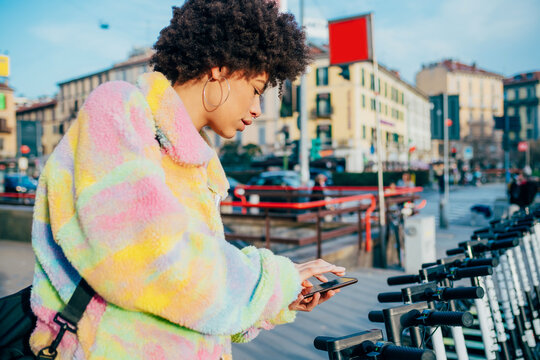 Young Middle Eastern Woman Outdoor Unlocking Electric Scooter