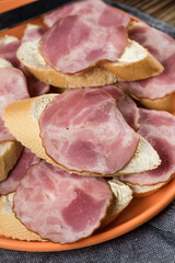 Sandwich made of wheat bread, butter and slices of dry-cured sausage.