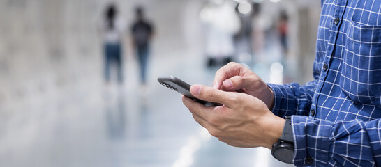 Young casual Businessman holding and using smartphone for sms messages, tourist man typing touchscreen cell phone in subway. business, lifestyle, technology and Social media network concepts