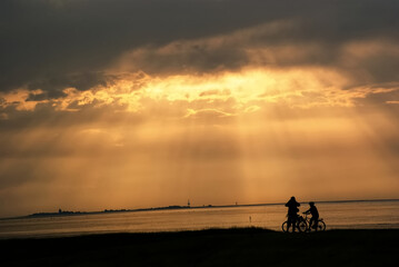 Fototapeta na wymiar Radfahrer Touristen am Meer im Sonnenuntergang 