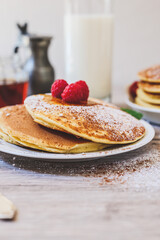 closeup of pancakes raspberries sugar and milk