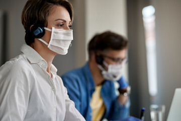 Call center agent wearing protective face mask while working during virus epidemic.