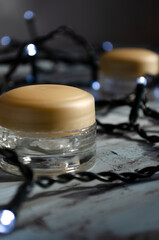 jars for cosmetics on a white background with garlands