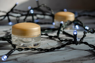 jars for cosmetics on a white background with garlands