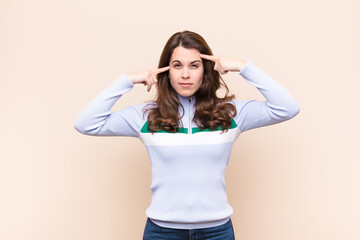 young pretty woman with a serious and concentrated look, brainstorming and thinking about a...