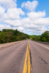 Fototapeta premium A highway through the woods in Warren County, Pennsylvania, USA on a sunny spring day