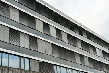 Facade of a corporate building. The windows are covered by exterior blinds consisting of thin horizontal lamellas