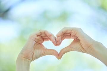 ハートマークを作る若い女性の手元
