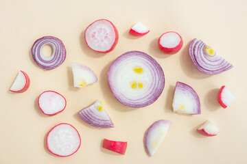 Red sliced onions and radishes on a light pastel background. The concept of healthy vegetables. Textural food background.