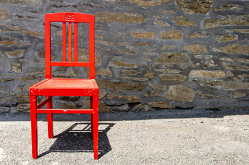 Fototapeta na wymiar Wooden red chair in the sun