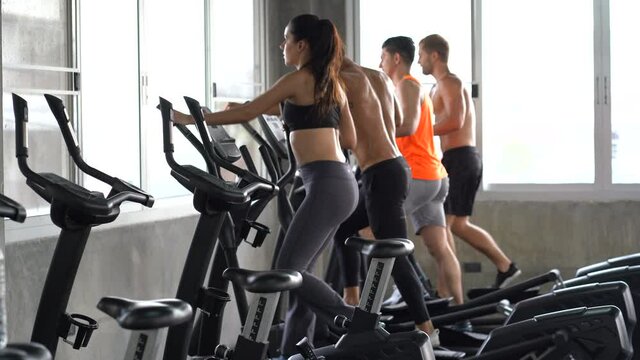 Fitness center. A group of young women and young boy train on sports training equipment in a fitness gym