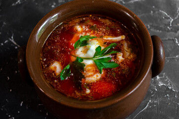 borsch in a clay pot with sour cream, brown bread and fresh herbs