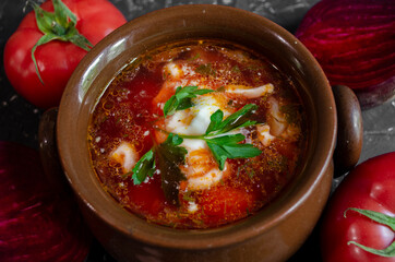 borsch in a clay pot with sour cream, brown bread and fresh herbs