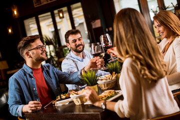 Group of young people having dinner in the restaurant