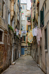 Fototapeta na wymiar Clothes hanging on a clothesline in a narrow street in Venice, Italy