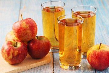 Glasses with apple juice and ripe apples